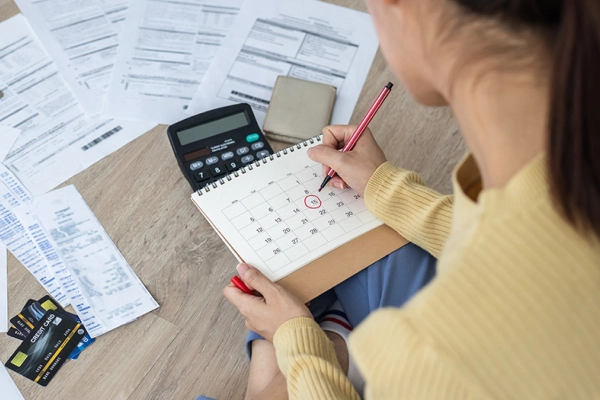 woman sitting at a table paying her bills