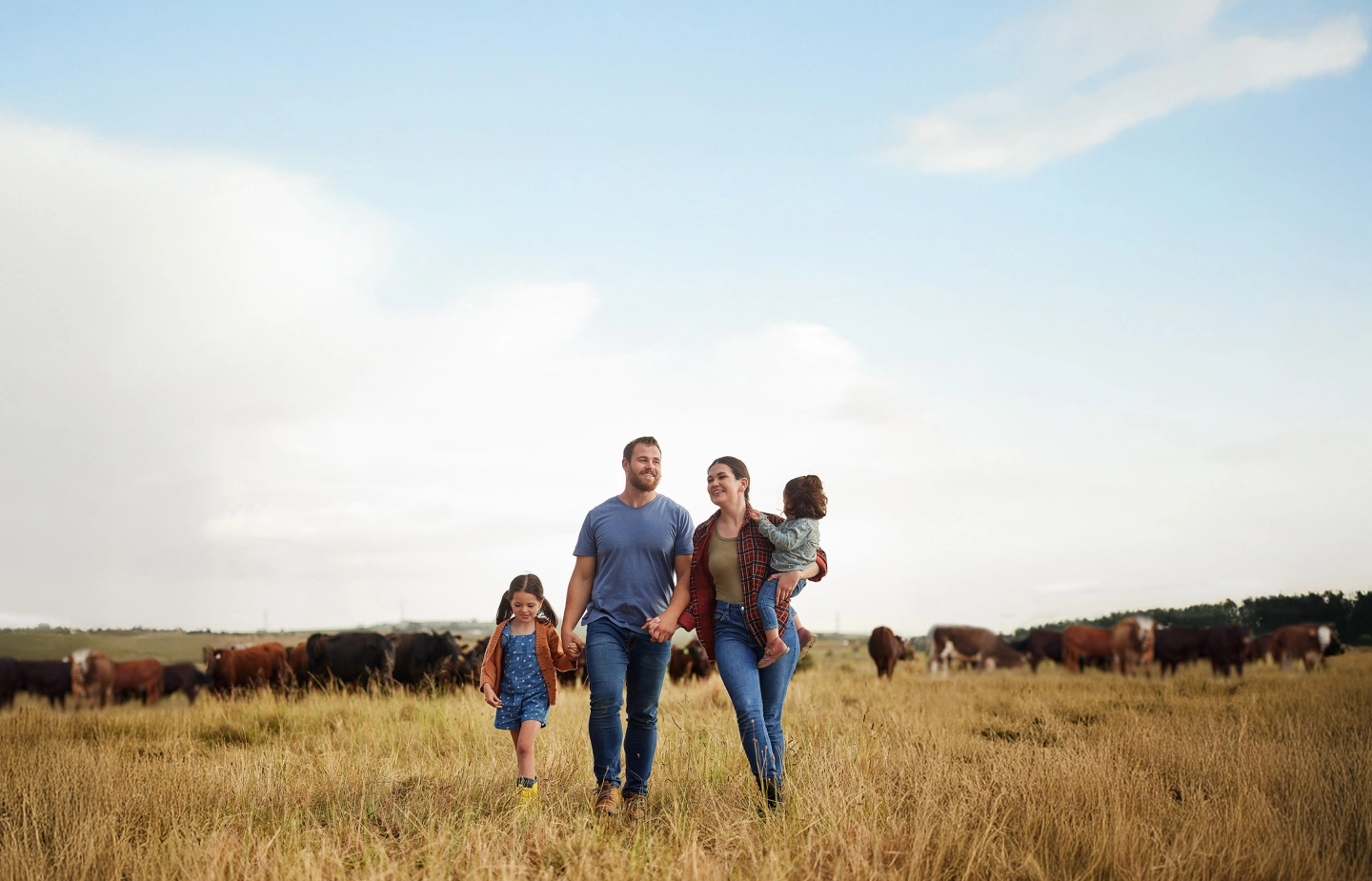 a mother, father, and their two childrens in a field